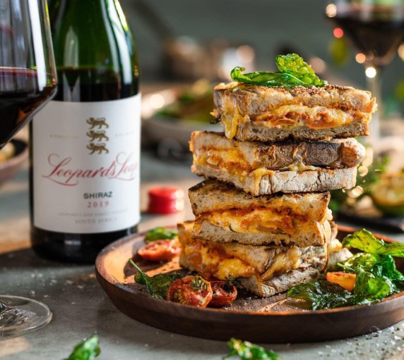Toasted sandwiches served with vegetables and a bottle of red wine at Mbizi’s restaurant