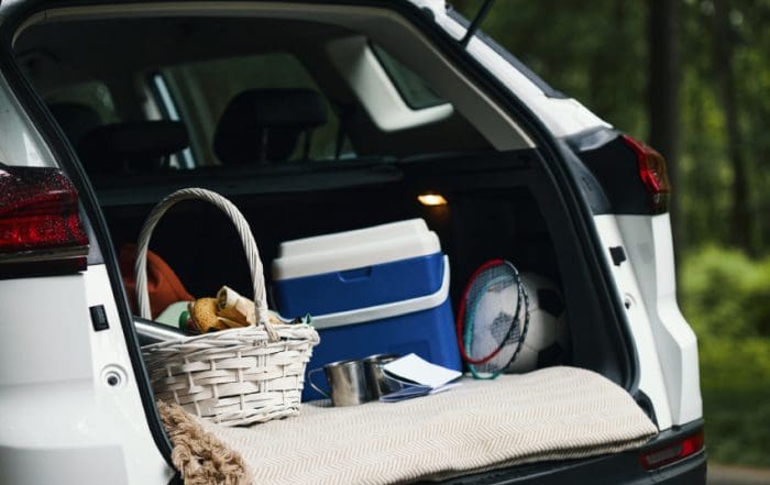 Car Trunk Packed with Picnic Basket and Sports Equipment during Family Road Trip