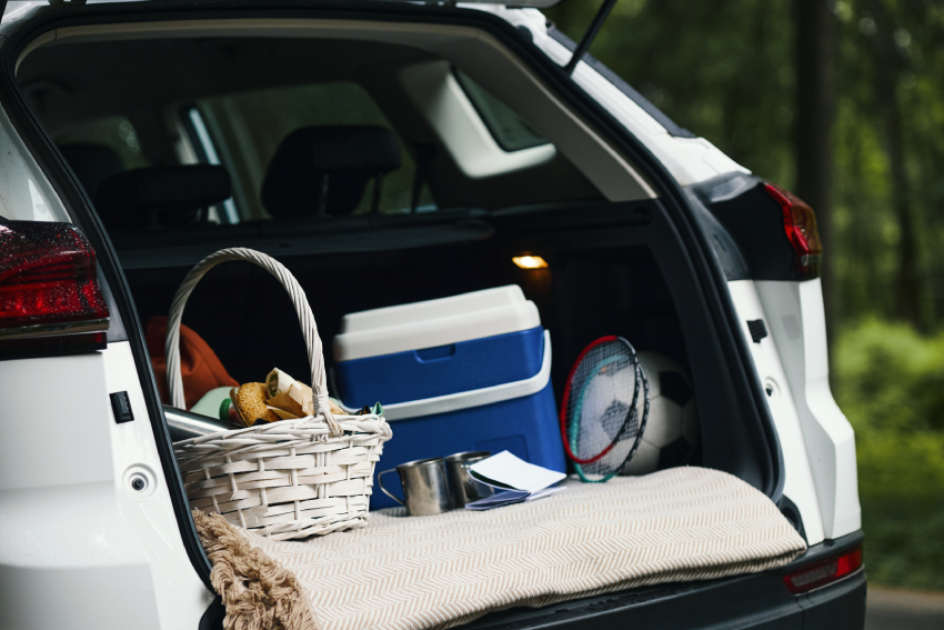 Car Trunk Packed with Picnic Basket and Sports Equipment during Family Road Trip